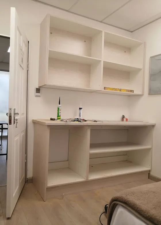 Light wood built-in wall cupboards and base units being installed